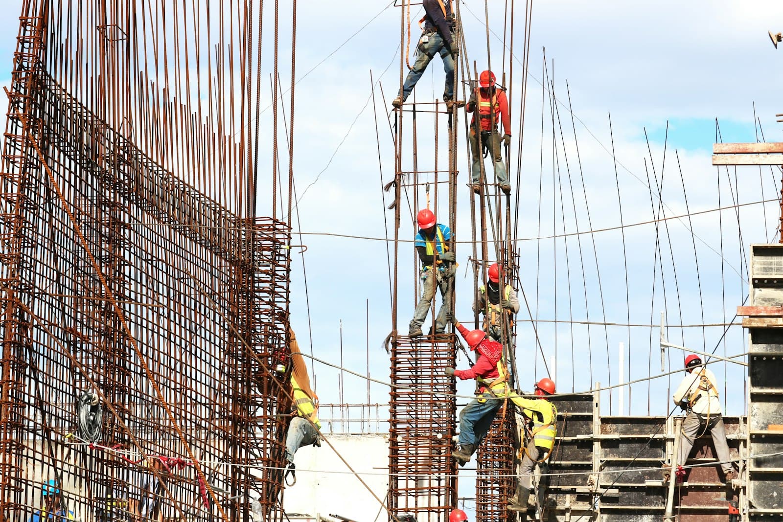 Tukang besi memasang tulangan kolom struktur gedung bertingkat