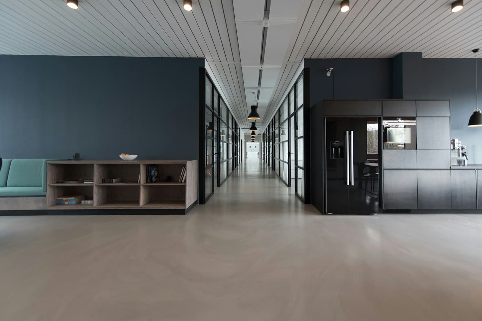 Koridor kantor modern dengan pantry dan lantai beton poles